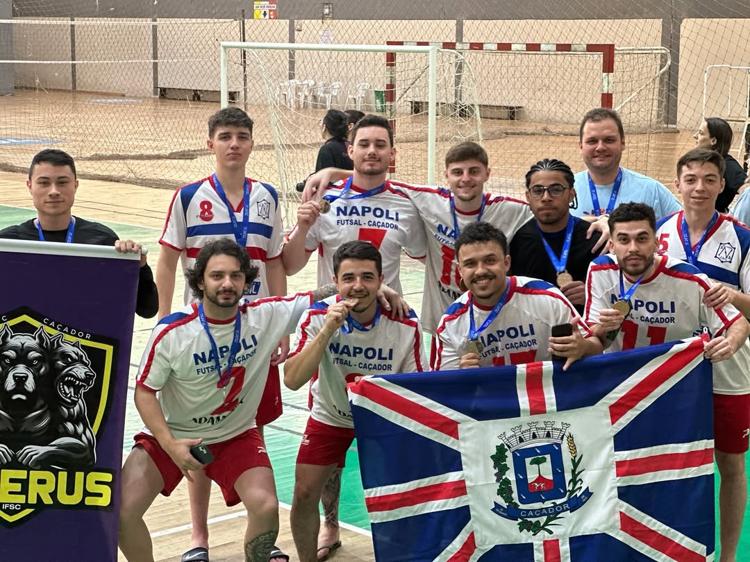 Imagem de time com comemorando 3º lugar, com medalha.